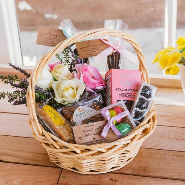 Easter Basket featuring chocolate bunnies, cookies, caramel eggs and fresh Spring flowers.